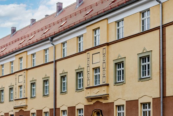 Wohnblock Nahaufnahme von Fassade it Fenster. Fenster haben Ornamente als Gestaltung, manche in grün andere haben in der Architektur eine Gestaltung.